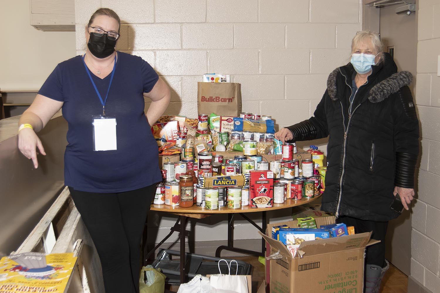 Carleton Place comiccon is a fundraiser for their local foodbank. An organiser and a representative of the foodbank pose with a portion of the food collected.